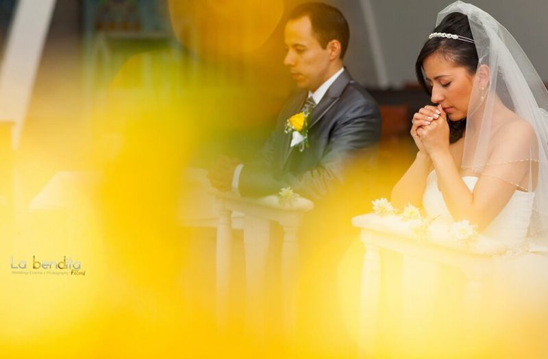 Novios arrodillados en el altar